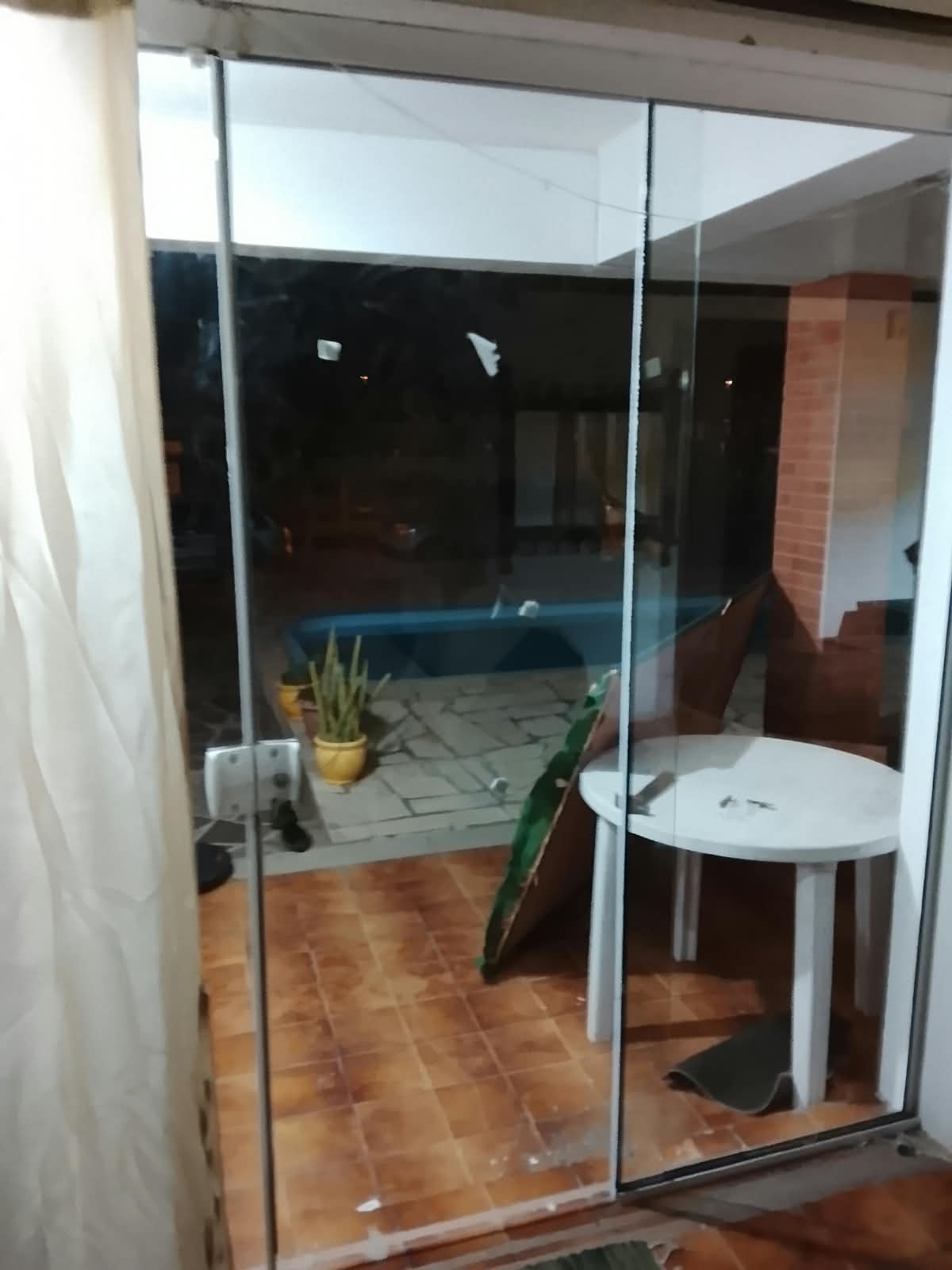 Porta de vidro de correr dando acesso à área externa com piscina