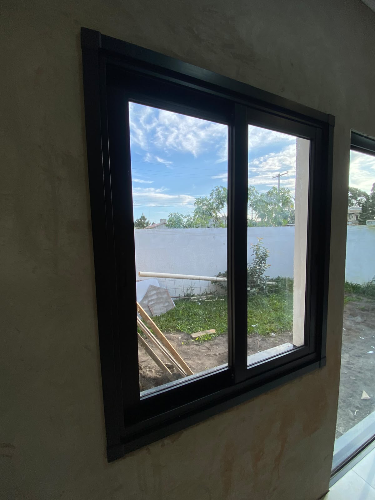 Janela deslizante com perfil preto em ambiente interno