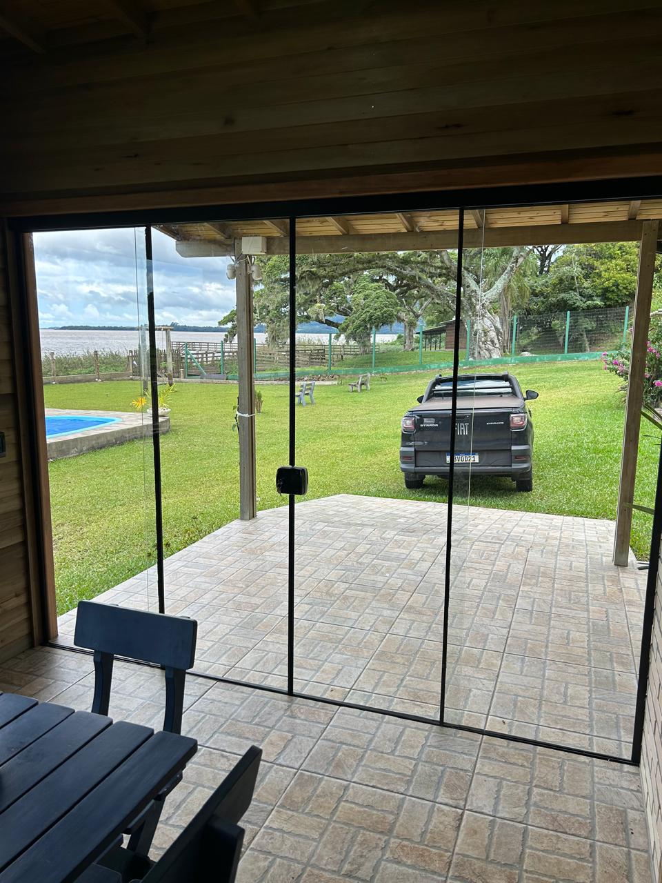 Fechamento de varanda em vidro com vista para o jardim